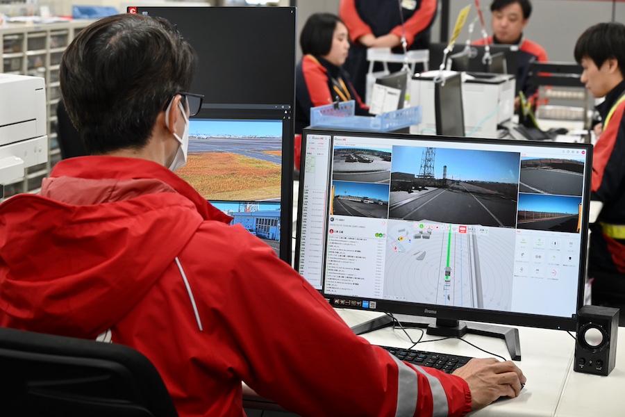 Autonomous TT vehicle and operators at Haneda Airport in Japan