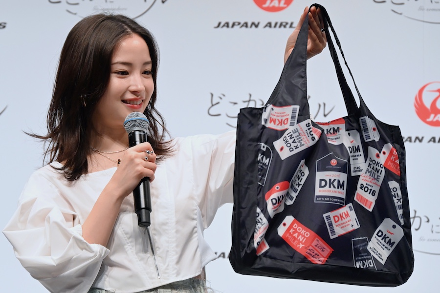 Suzu Hirose receiving an original eco-bag commemorating the 10th anniversary from a JAL representative
