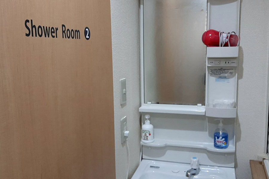 Individual shower rooms and shared hair dryer at Hotel Lucky